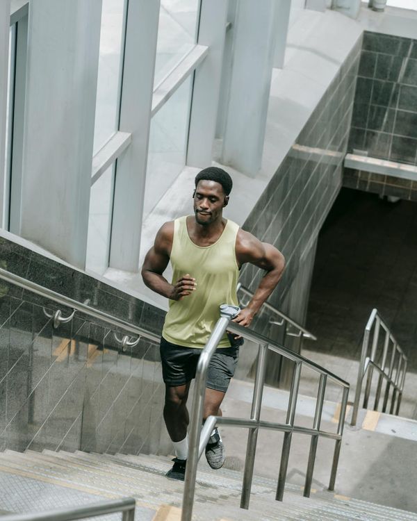 Man performing a controlled strength exercise in a modern gym.